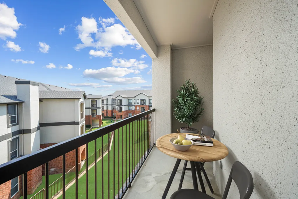 Charming balcony view with modern outdoor seating and vibrant apartment complex, perfect for relaxation.