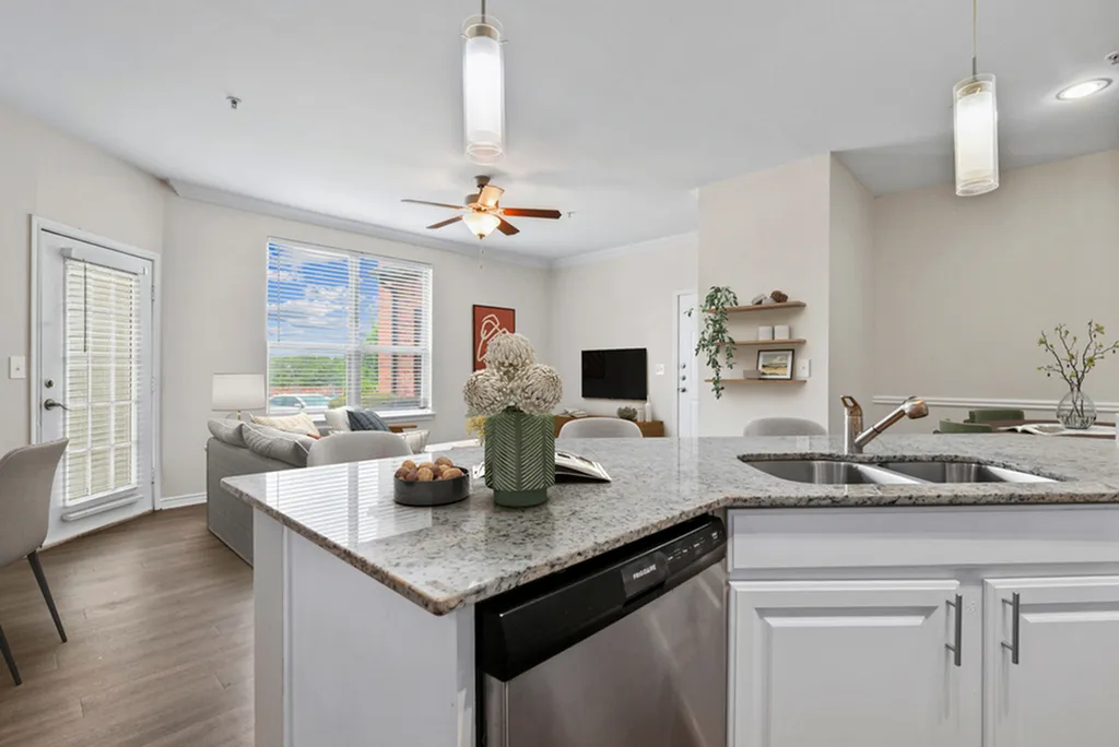 Kitchen with pendant lighting, granite counters, stainless steel appliances, white tile backsplash, hardwood flooring, and white cabinetry