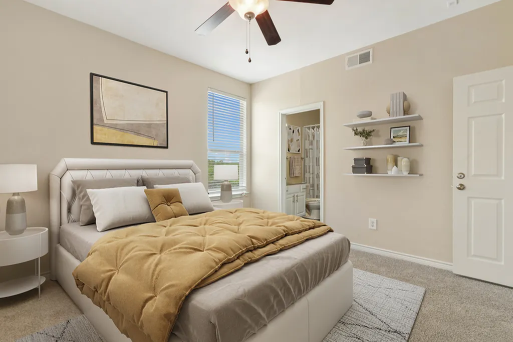 Inviting bedroom with modern decor, featuring a plush bed, stylish wall art, and built-in shelving. Natural light streams through the window.