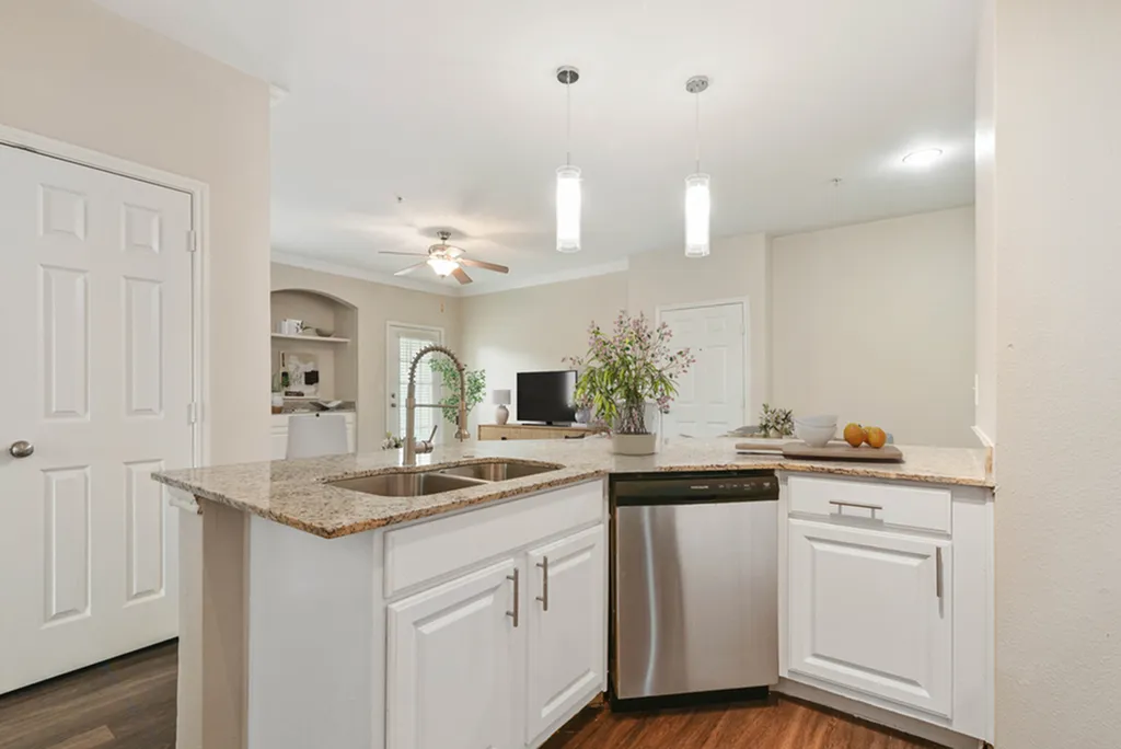 Kitchen with granite counters, white cabinetry, pendant lighting, hard wood flooring, and gooseneck faucet