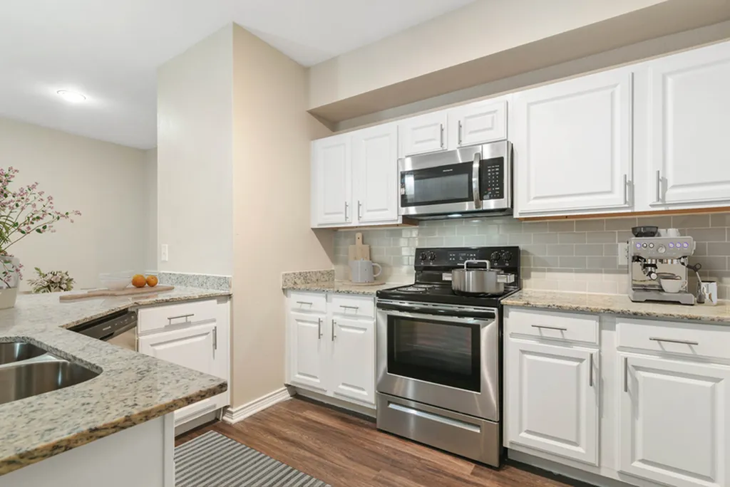Kitchen with granite counters, white cabinetry, pendant lighting, hard wood flooring, and gooseneck faucet