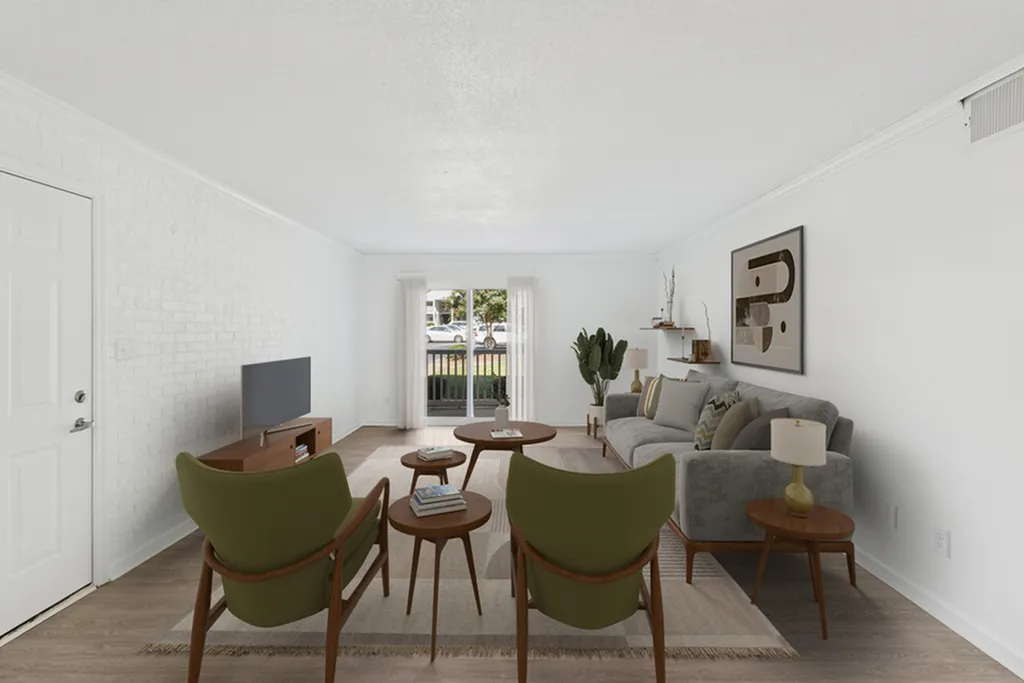 Bright and airy living room with modern decor, featuring a comfy gray sofa, stylish armchairs, and large windows bringing in natural light.
