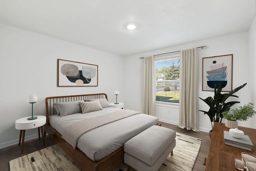 Bright and airy bedroom with stylish decor, featuring a comfortable bed, modern side tables, and a large window with garden views.