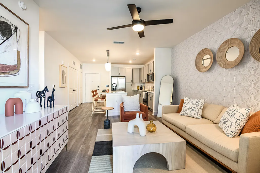 Chic modern apartment living area featuring stylish decor, sleek kitchen design, and cozy seating with artistic accents and warm ambiance.