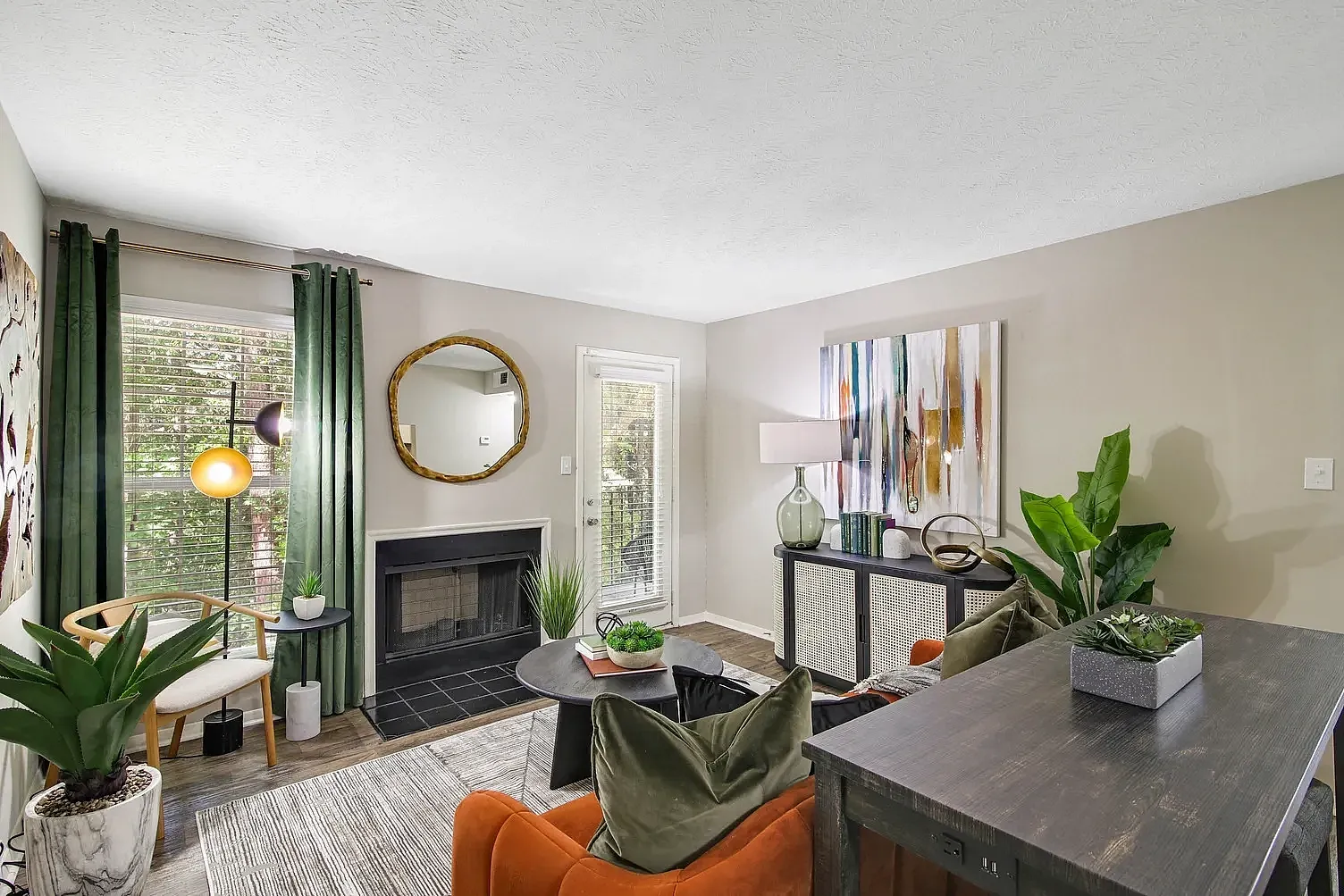 Furnished model living room with fireplace, hard wood style flooring and decor