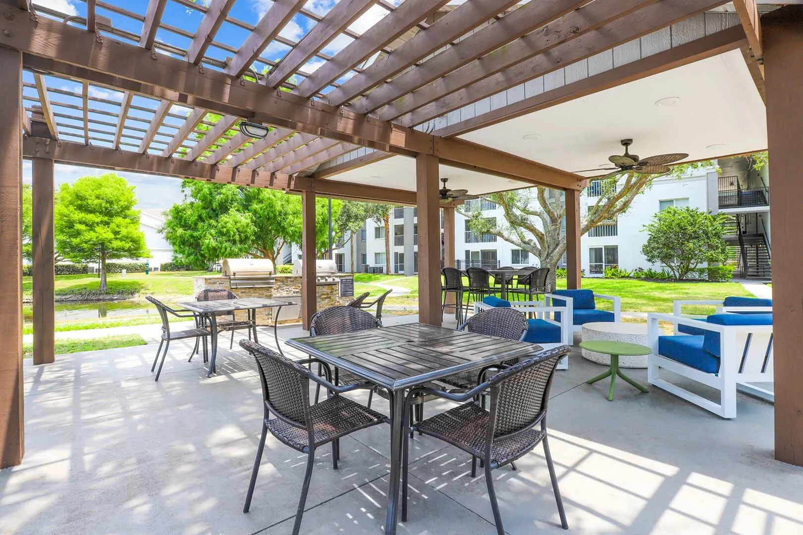 Outdoor grills with covered tables and chairs with outdoor ceiling fans.