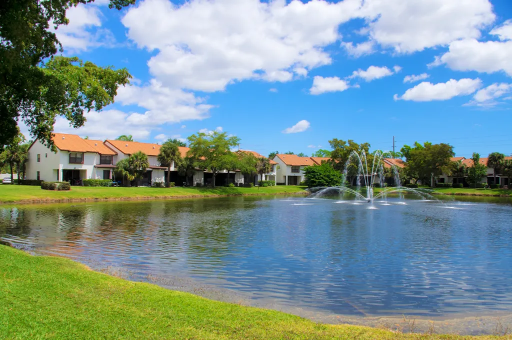 Lake with fountain in the middle surrounded by apatment buildings and native landscaping