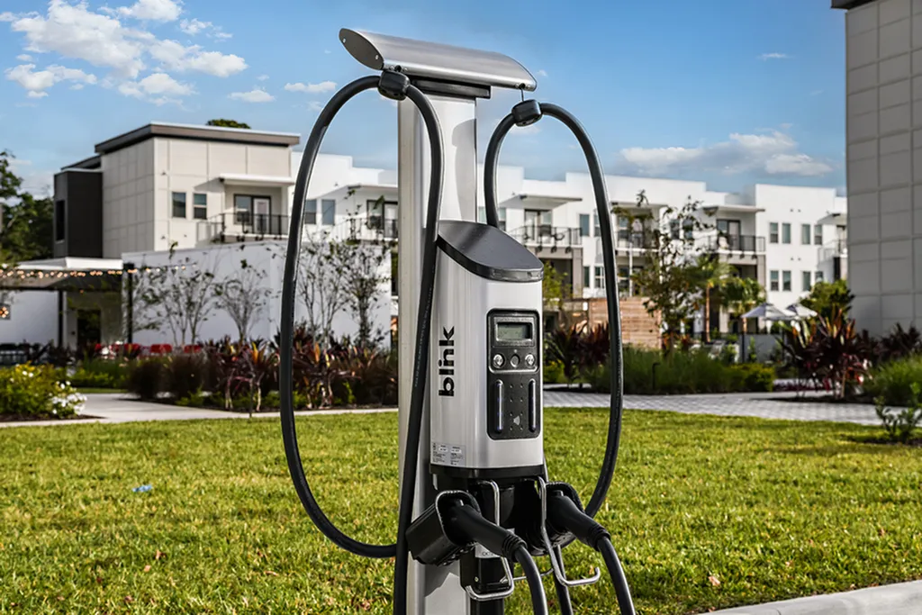 Modern apartment complex with electric vehicle charging station set amidst lush greenery and contemporary architecture.