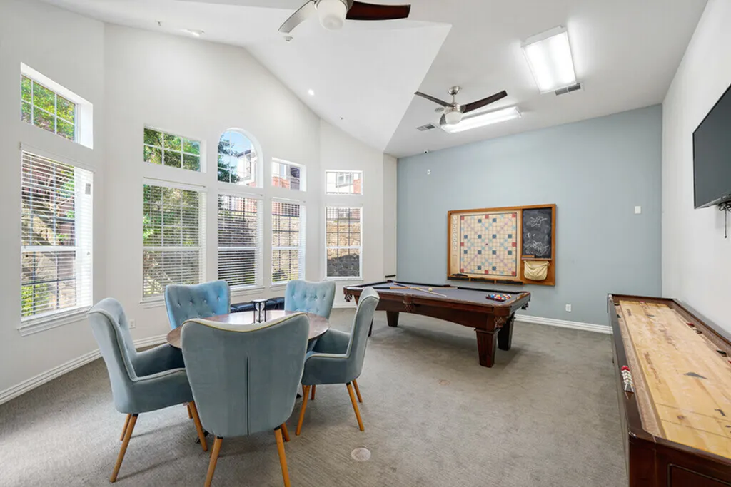 Bright and inviting game room with modern ceiling fans, games, and stylish seating for a perfect gathering spot.