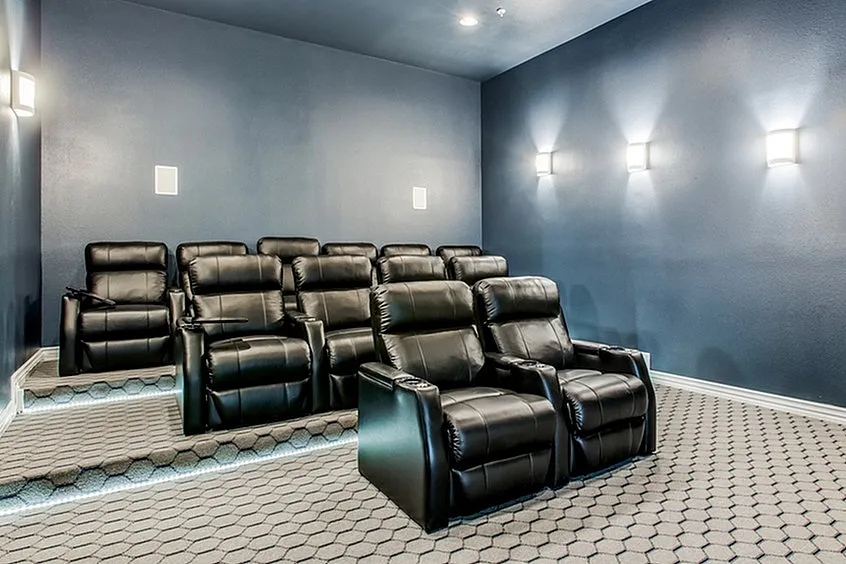 Luxurious home theater with plush recliner seating and modern lighting, perfect for entertainment enthusiasts.