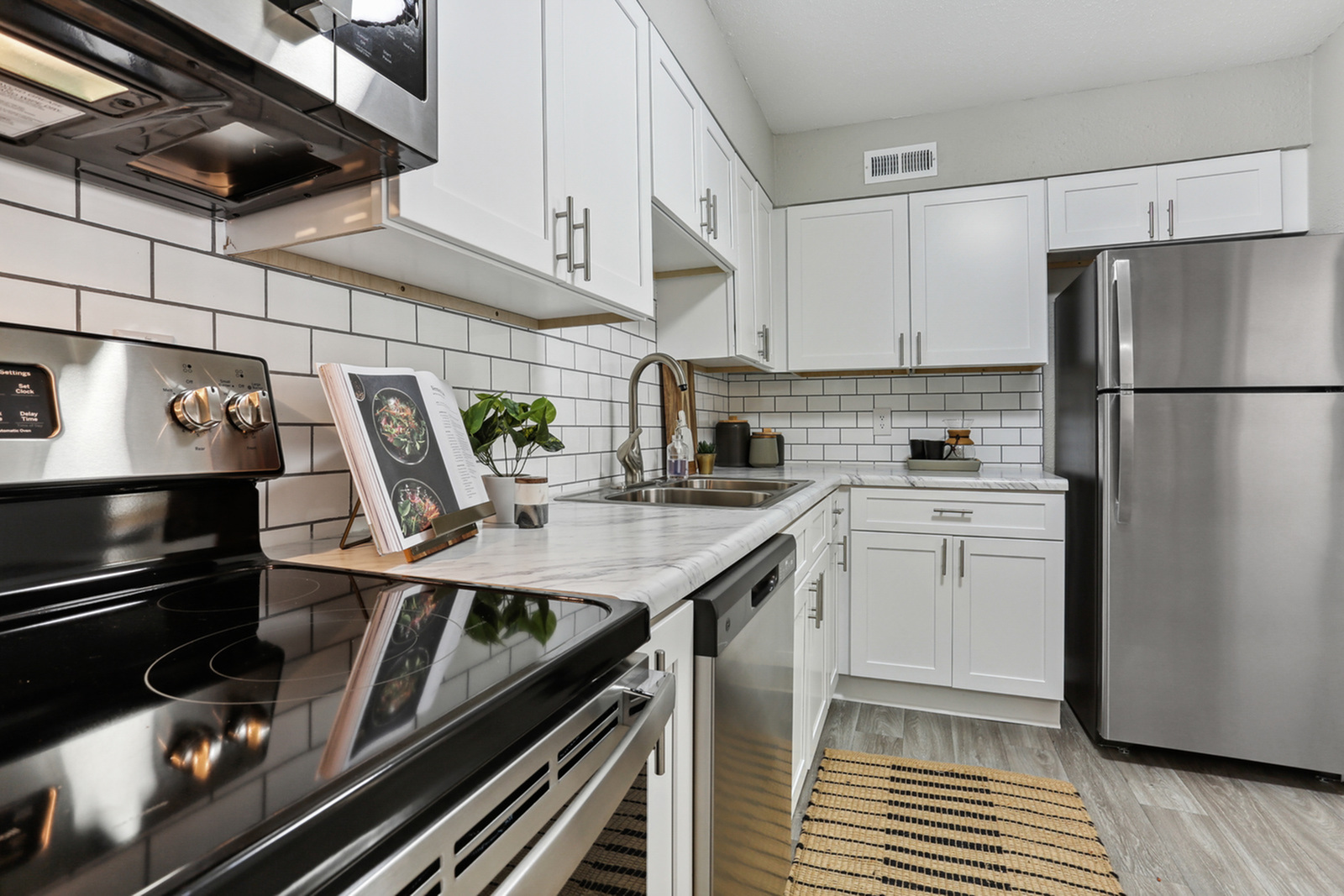 Modern kitchen with sleek stainless steel appliances, elegant white cabinetry, and a stylish subway tile backsplash.