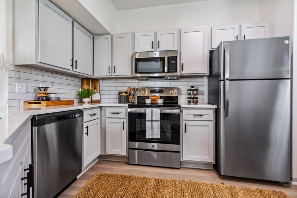 Modern kitchen with sleek stainless steel appliances, elegant cabinetry, and a stylish subway tile backsplash for a chic culinary space.