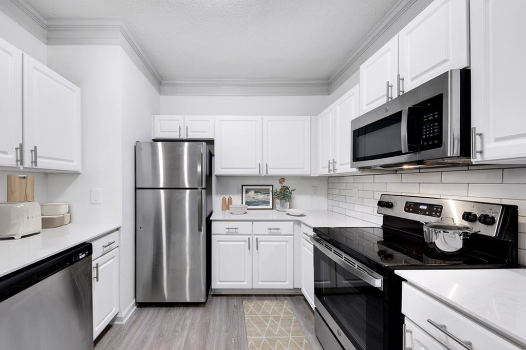 Modern kitchen with sleek stainless steel appliances, elegant white cabinetry, and stylish subway tile backsplash.