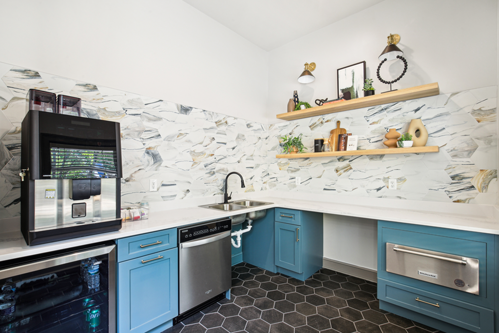 Modern kitchen featuring stylish blue cabinets, sleek appliances, and decorative open shelves with lush plants.