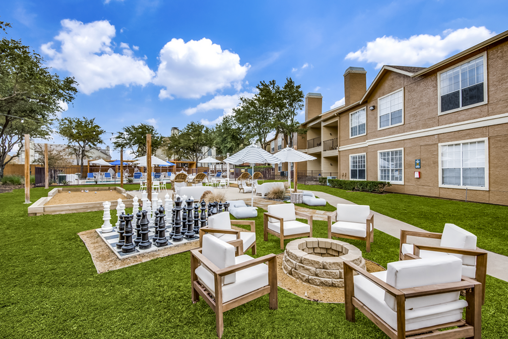 Luxurious outdoor courtyard with a fire pit, modern seating, and a life-sized chess board, perfect for social gatherings.