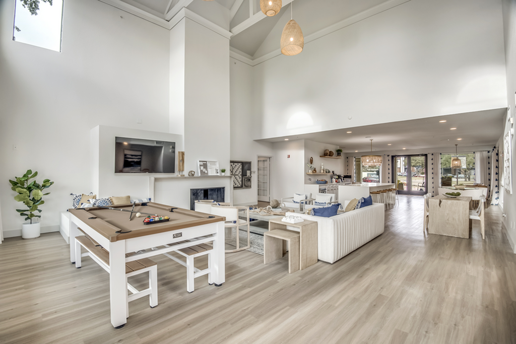 Luxurious and spacious clubhouse with high ceilings, featuring modern decor and a stylish billiards table, perfect for entertainment.