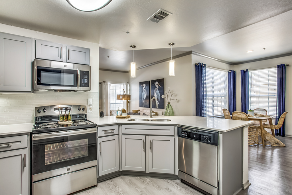 Modern kitchen with sleek stainless steel appliances, elegant countertops, and a cozy dining area with natural light.
