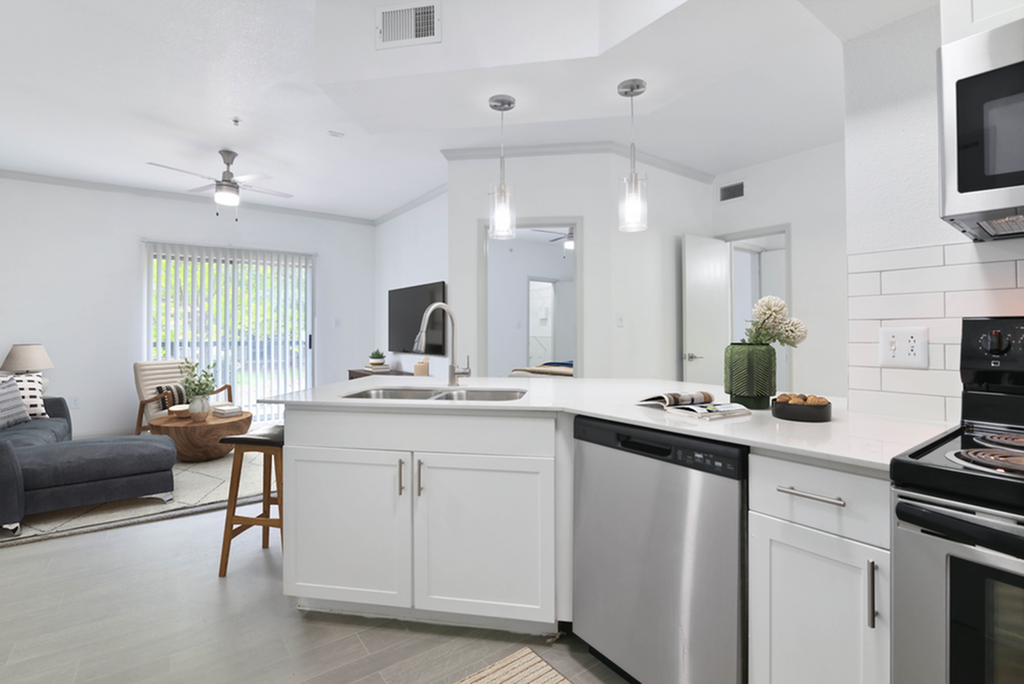 Contemporary open-plan kitchen and living room with sleek countertops, modern appliances, and ample natural light.