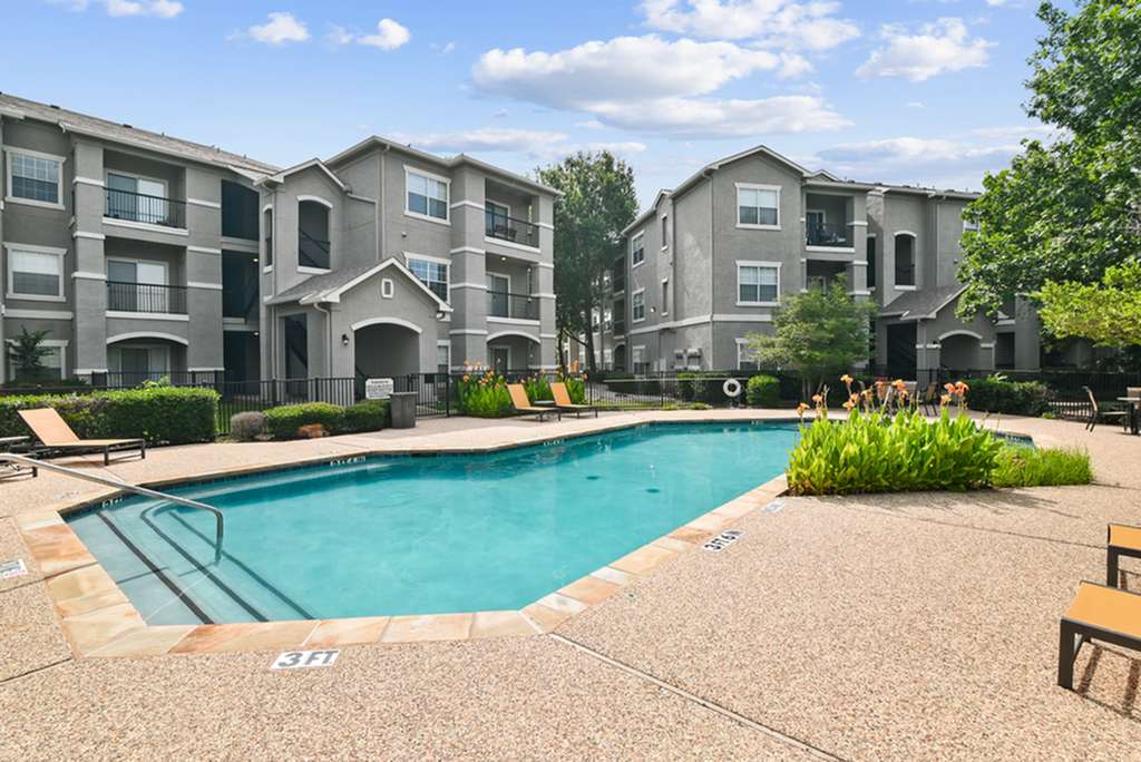Elegant apartment community with modern architecture and inviting swimming pool area, perfect for relaxation and leisure.