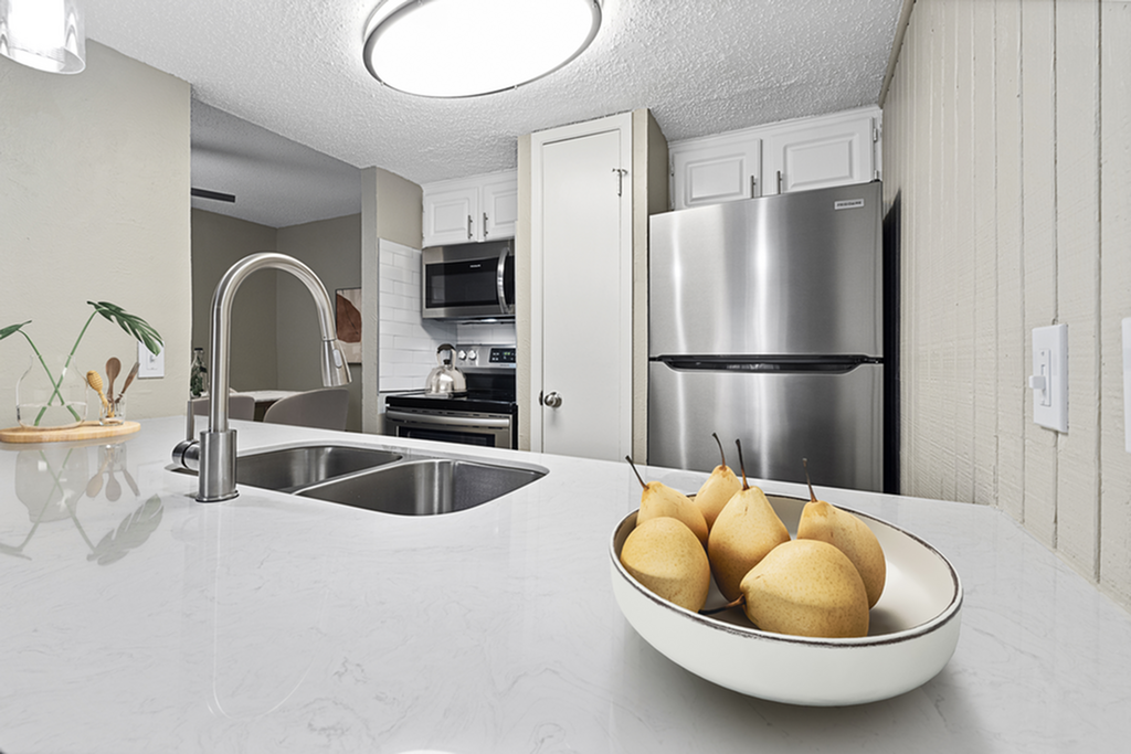 Sleek modern kitchen with stainless steel appliances, elegant marble countertops, and stylish decor in a bright, inviting setting.