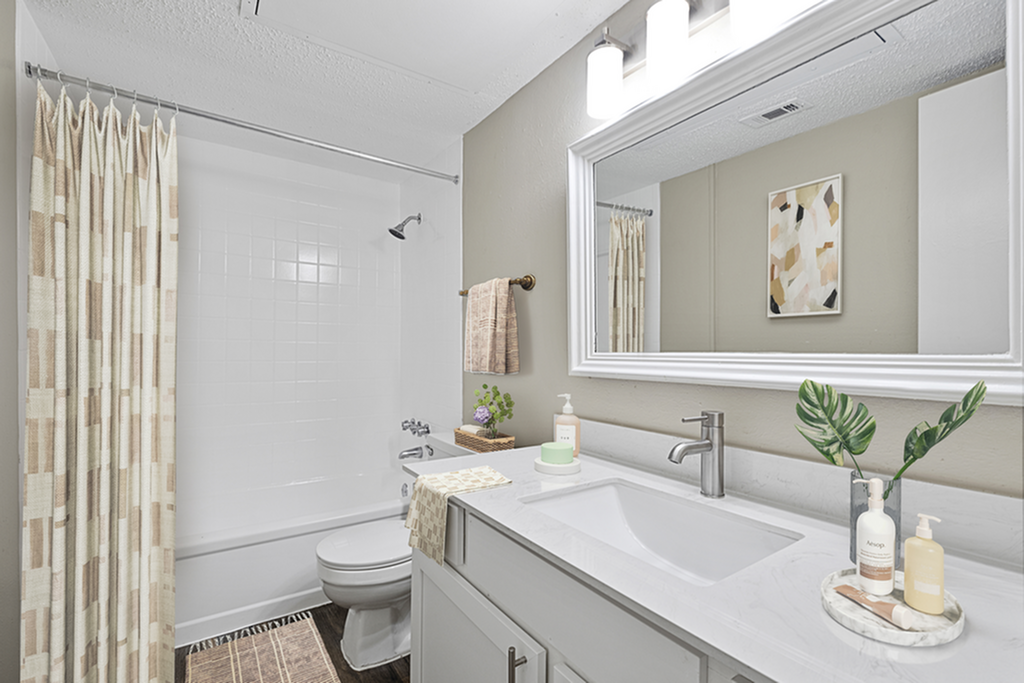 Elegant bathroom design featuring a large mirror, sleek vanity, and cozy shower area adorned with modern geometric accents.