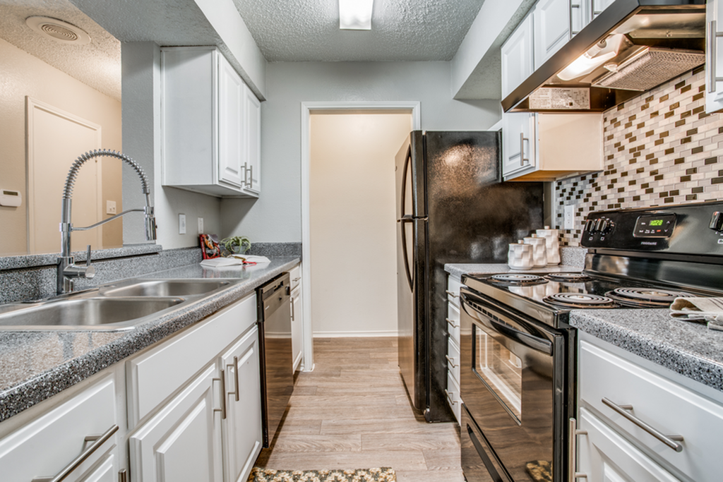 Modern kitchen with sleek stainless steel appliances, granite countertops, and contemporary cabinetry featuring a stylish backsplash.