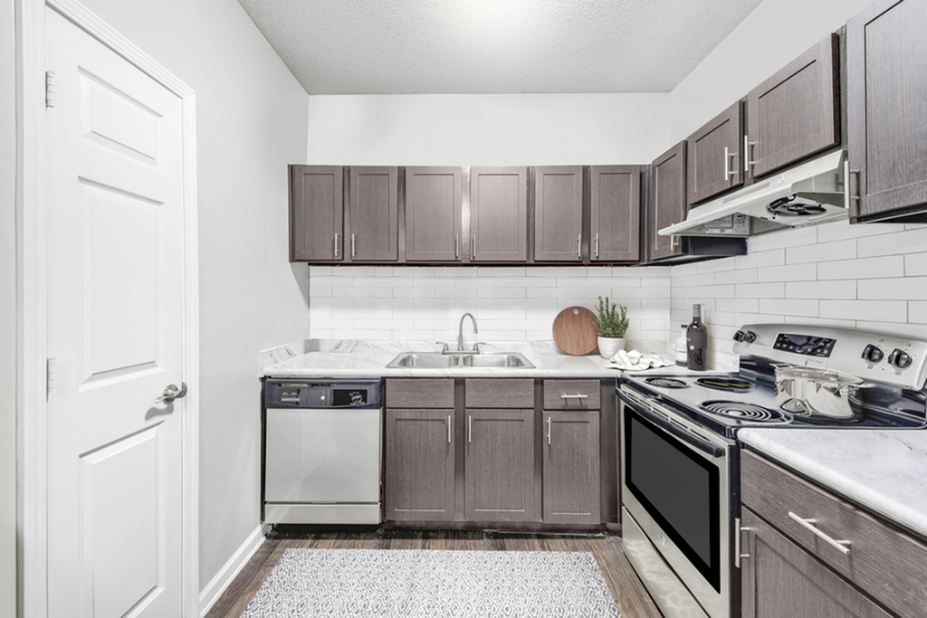 Modern kitchen with sleek dark wood cabinetry, stainless steel appliances, and elegant marble countertops.