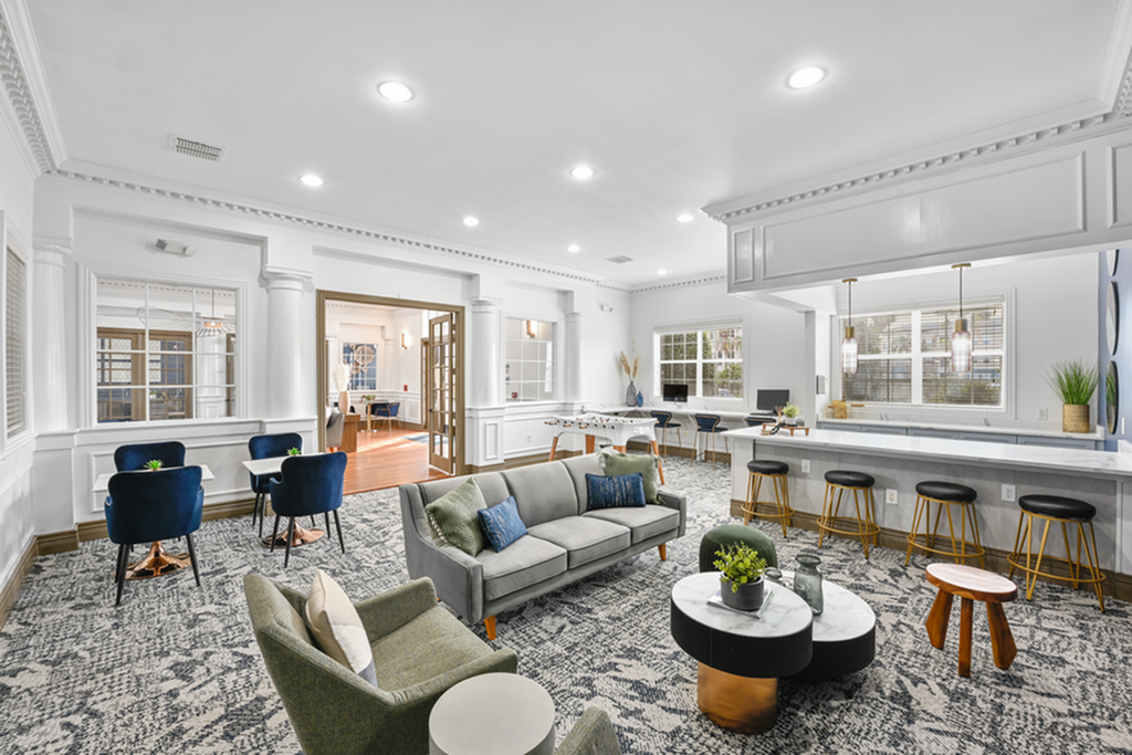 Elegant and spacious clubhouse area featuring plush seating, modern decor, and ample natural light; perfect for social gatherings or relaxation.