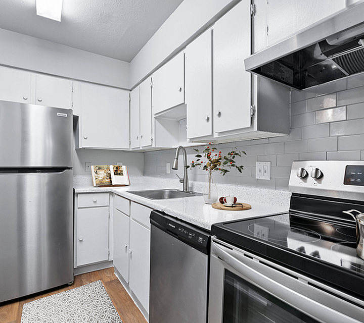 Kitchen with Vinyl floors, stainless-steel appliances, white quartz countertop,