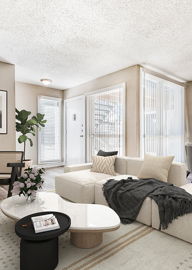Table with couch and large windows with plants