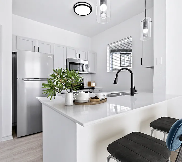 Sleek modern kitchen with stainless steel appliances, elegant pendant lighting, and a stylish breakfast bar with comfortable seating.