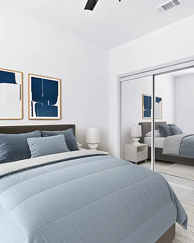 Elegant bedroom with modern decor, featuring a cozy bed, mirrored closet, and abstract art on the walls.