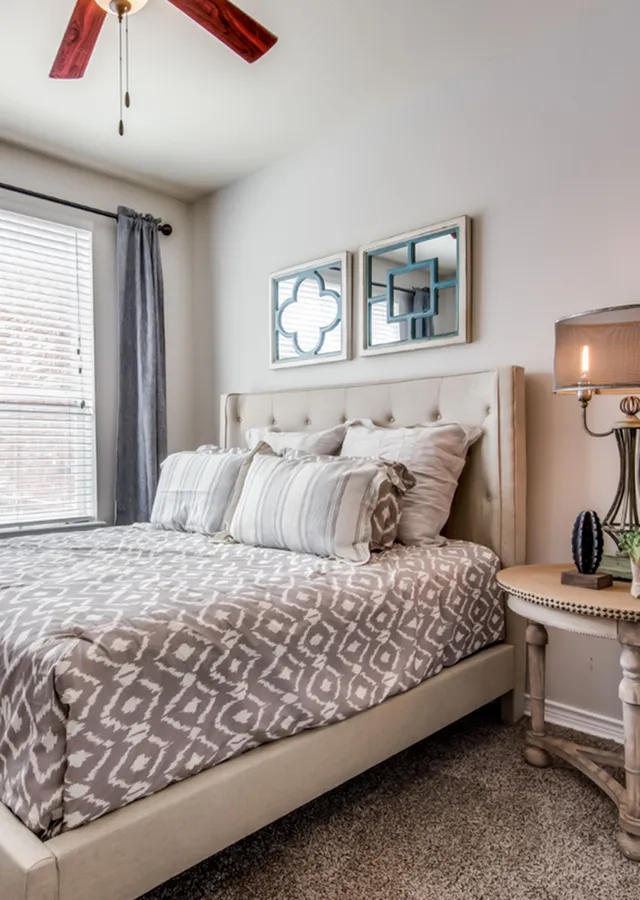 Cozy bedroom featuring a plush upholstered bed with elegant bedding, soft lighting, and modern decor accents.