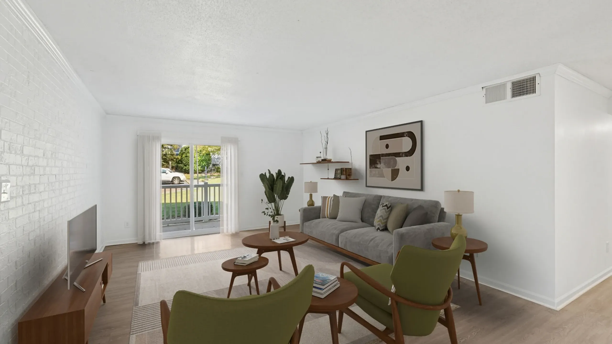 Elegant living room with modern furniture, featuring a cozy gray couch, stylish green chairs, and a large window overlooking lush greenery.