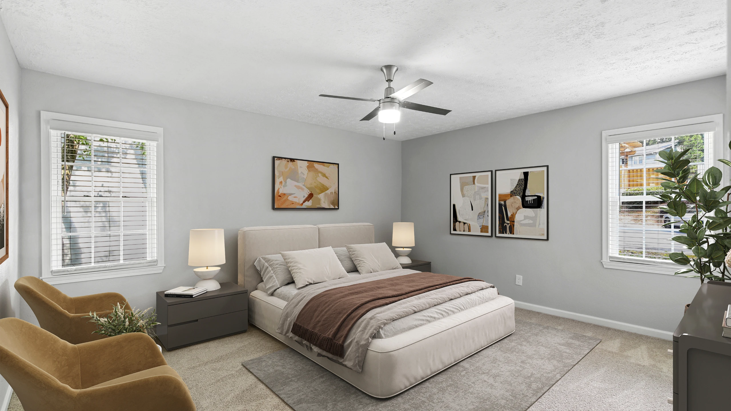 Spacious modern bedroom with plush carpeting, a low-profile upholstered bed, contemporary artwork, and soft neutral d&eacute;cor. The room features large windows with natural light, matching nightstands with lamps, a ceiling fan, and cozy a