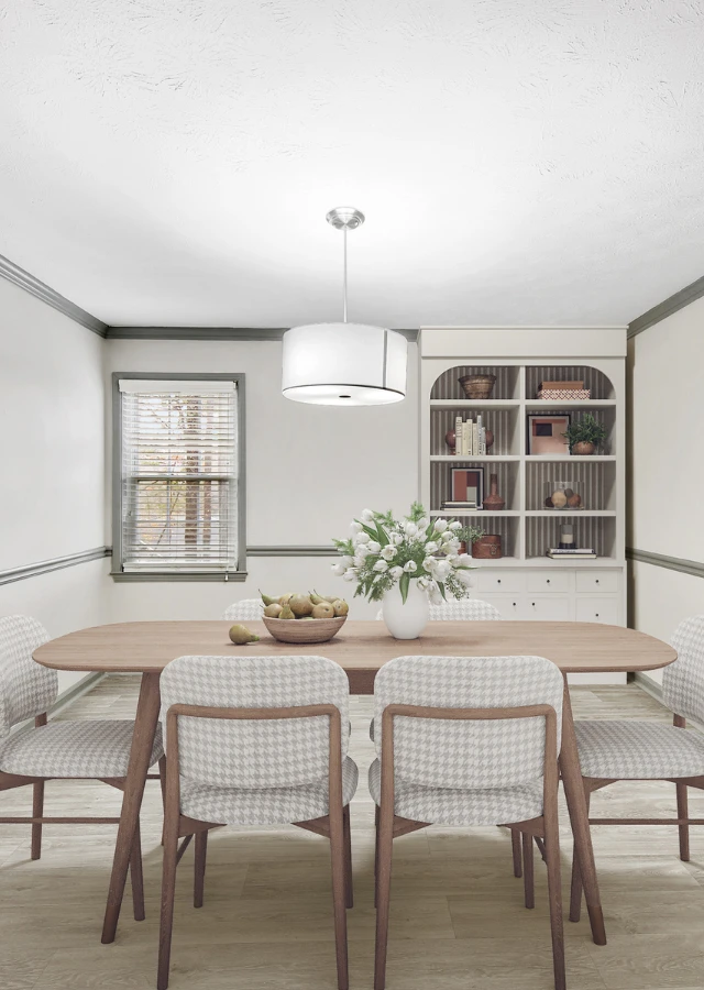 Modern dining room with a light wood dining table, upholstered seating, and a contemporary pendant light. The space features neutral tones, decorative built-in shelving, wood-style flooring, and elegant d&eacute;cor accents creating a warm