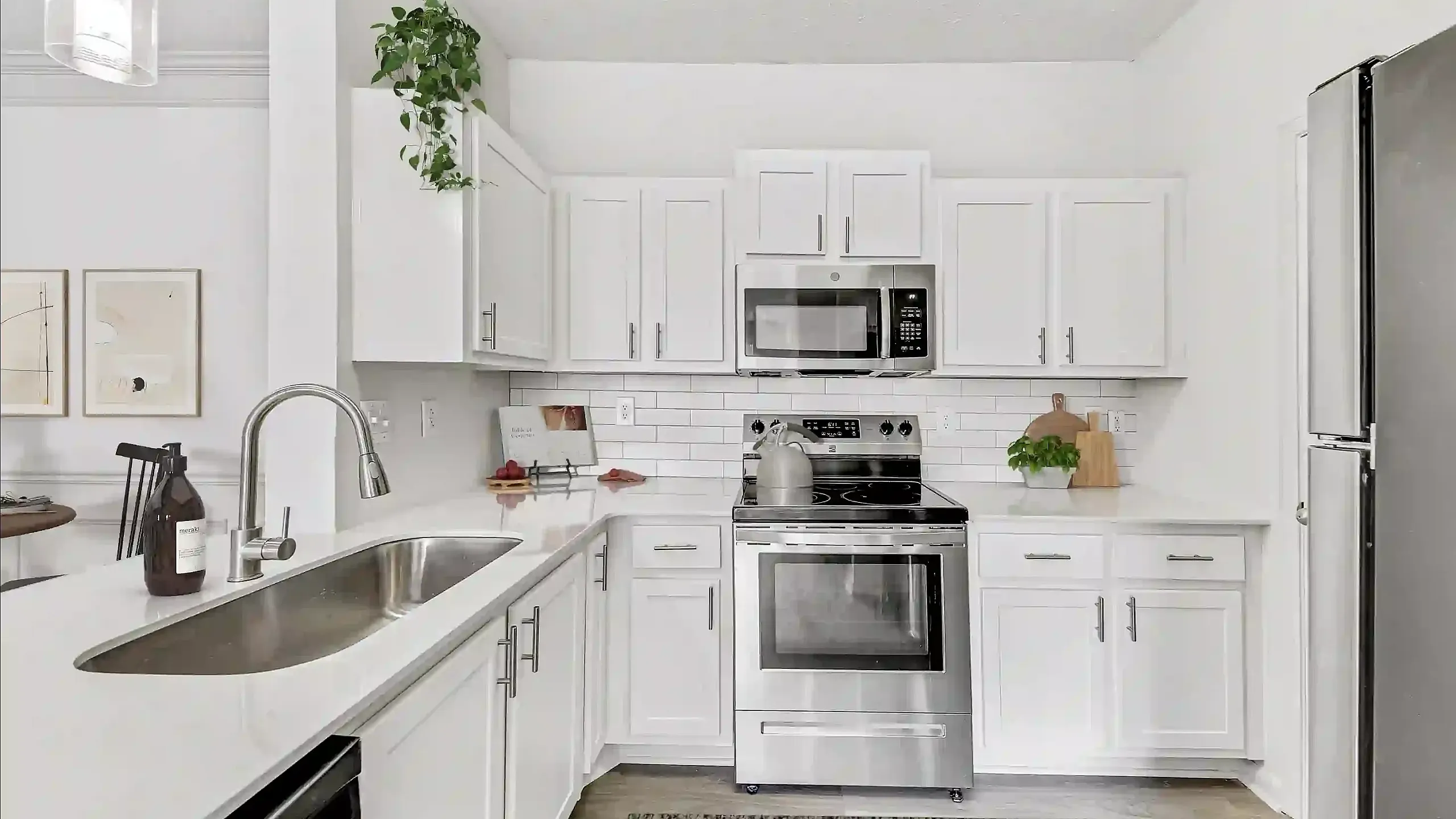 Chic modern kitchen featuring sleek white cabinetry, stainless steel appliances, and elegant countertop finishes.