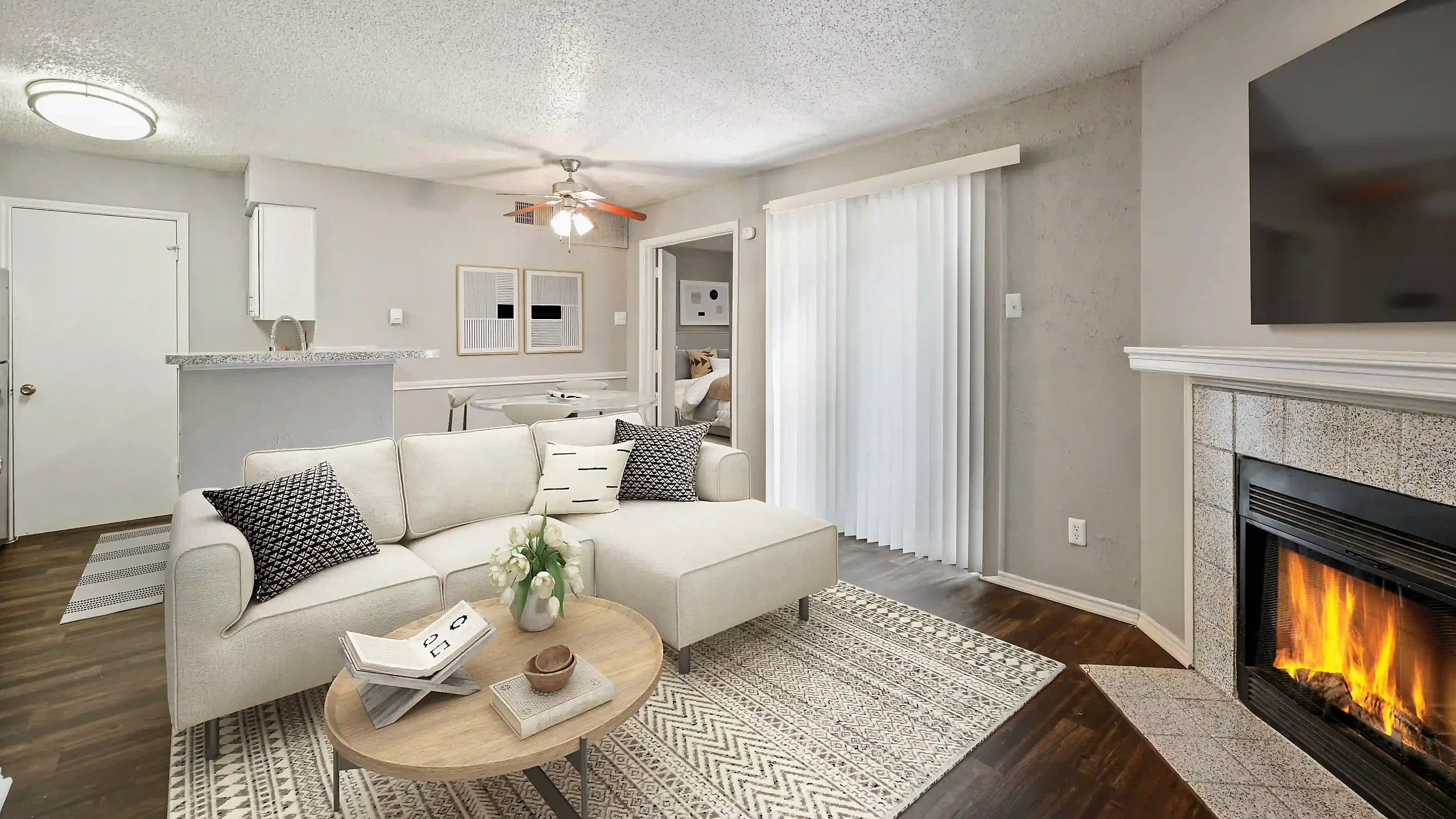 Inviting open-plan living room with cozy fireplace, modern kitchen, and elegant decor in a bright apartment.