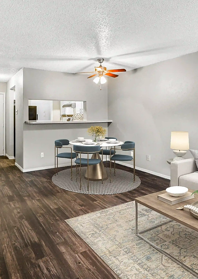 Modern living room with elegant wooden flooring, cozy seating area, and stylish decor, seamlessly blending into an open dining space.