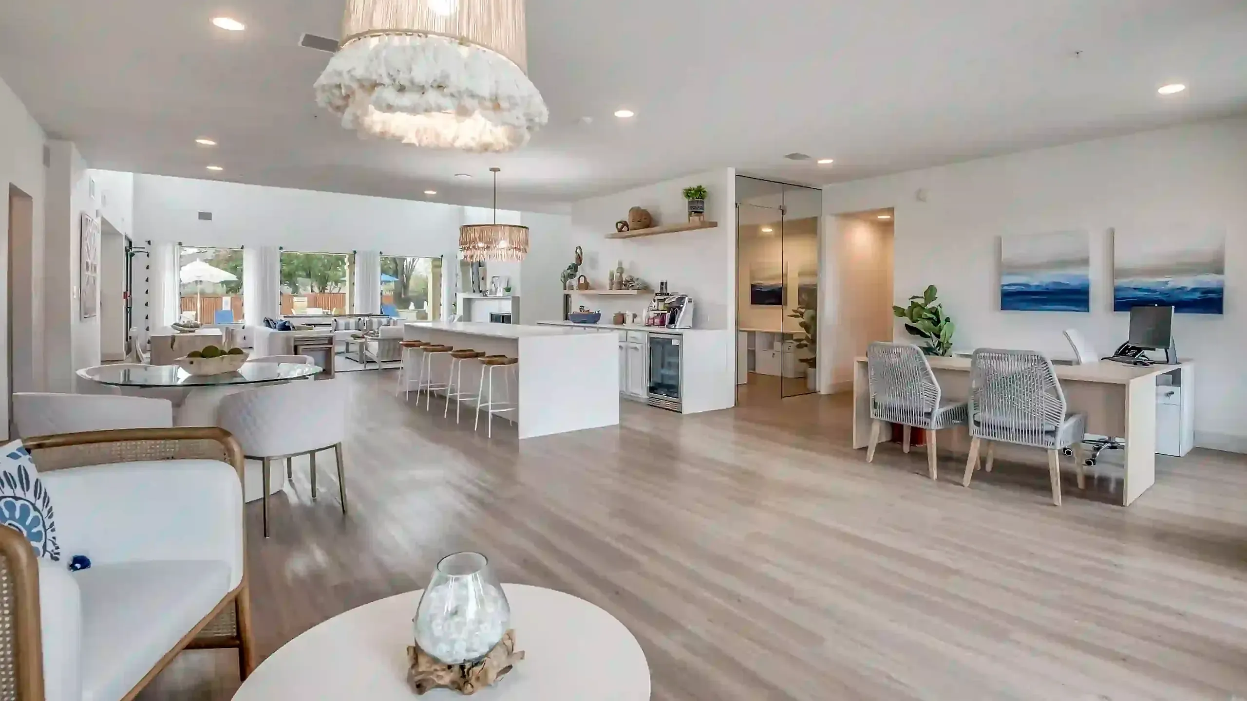 Spacious open-concept living area with stylish modern decor, featuring a chic kitchen island with bar seating, elegant lighting, and a cozy seating area with contemporary furnishings.
