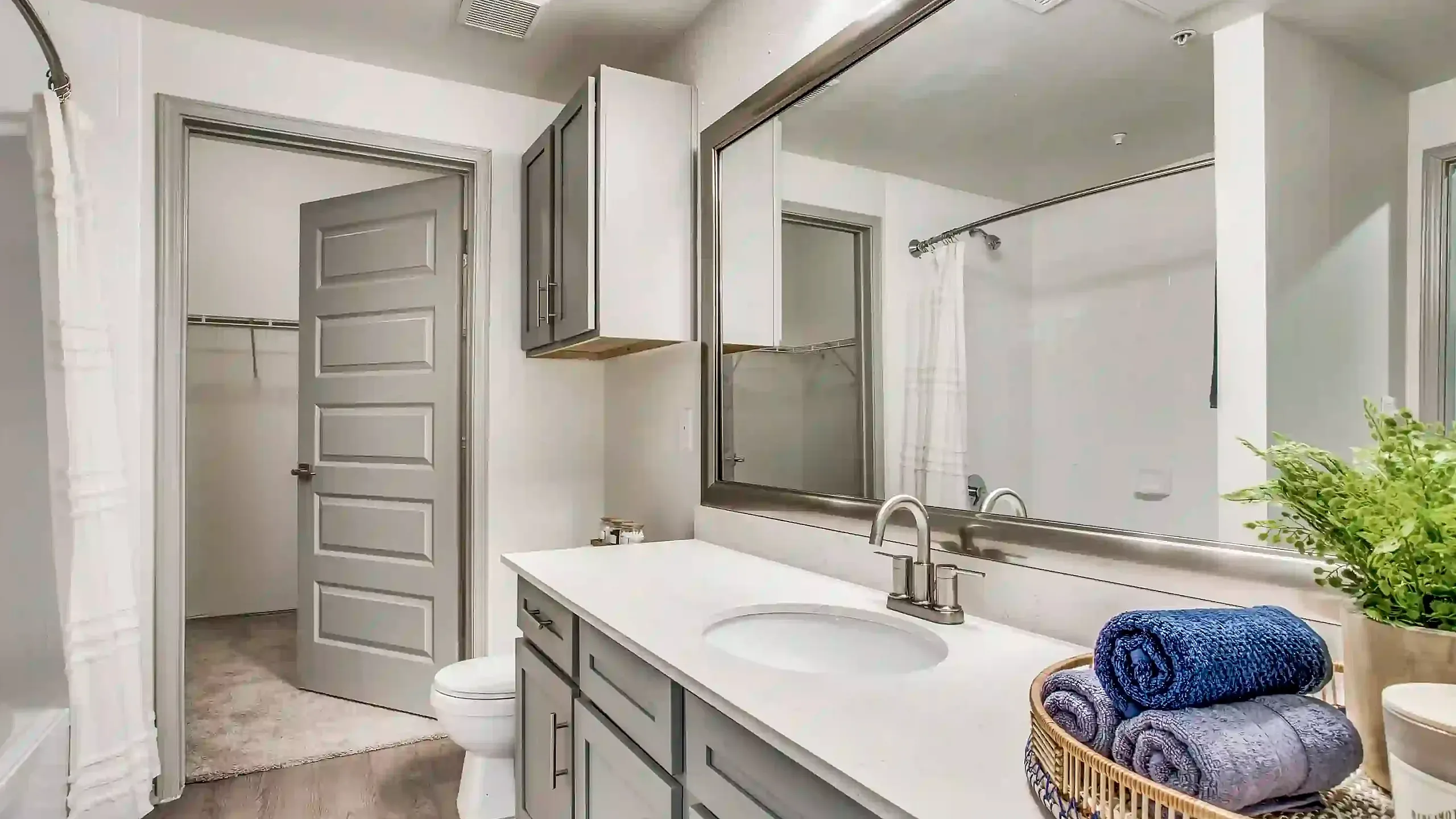 Modern bathroom featuring sleek double vanity, large mirror, and plush towels, creating a spa-like retreat.