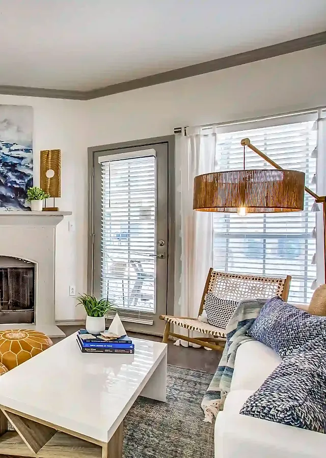 Modern living room with a cozy fireplace, stylish decor, and abundant natural light through large windows.