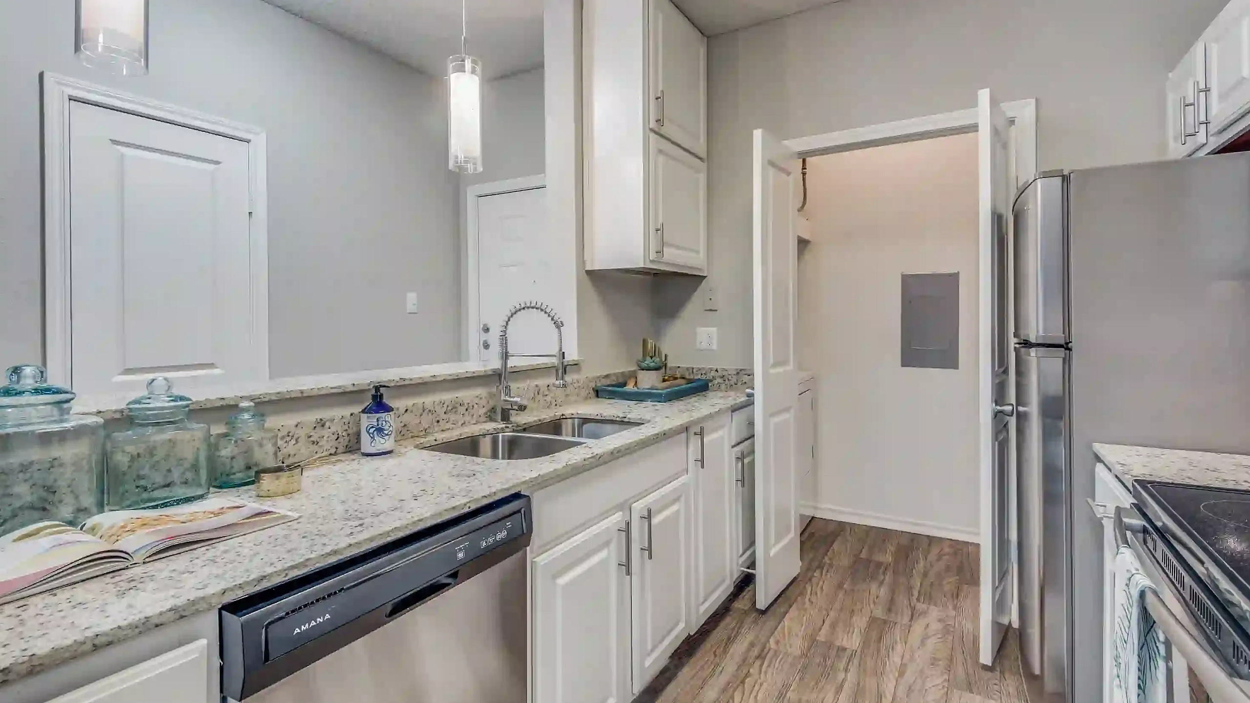 Modern kitchen with sleek stainless steel appliances, elegant granite countertops, and stylish pendant lighting, perfect for culinary enthusiasts.