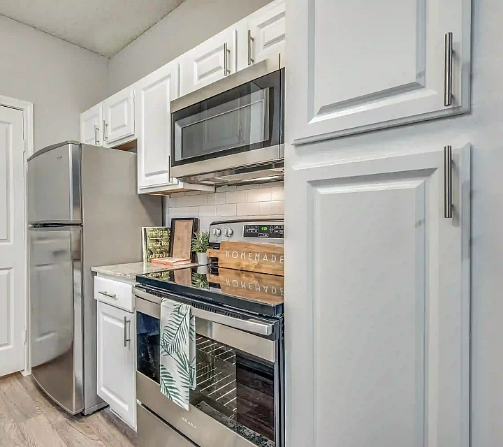 Modern kitchen with sleek stainless steel appliances, granite countertops, and elegant white cabinetry providing ample storage.