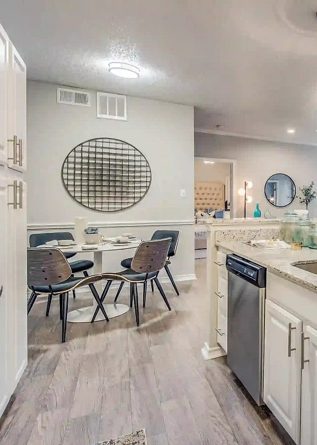 Elegant open-concept kitchen and dining area with granite countertops, modern lighting, and stylish decor.