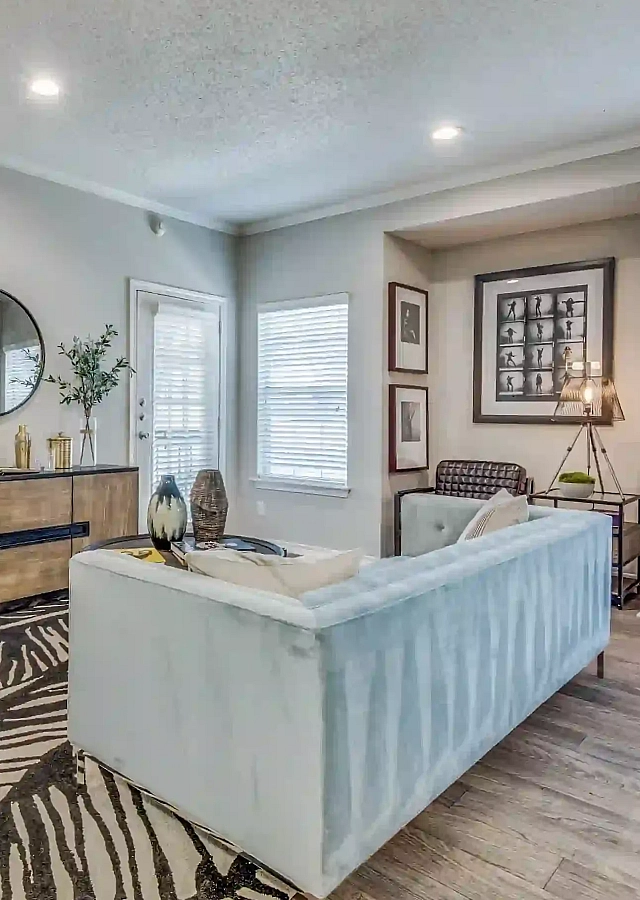 Inviting living room with elegant decor, cozy seating area, and natural light, adjacent to a stylish bedroom with plush bedding.