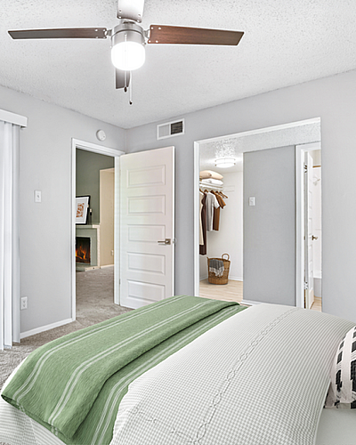 Bright and inviting bedroom with sliding glass doors leading to a private balcony, showcasing a cozy and modern interior design.