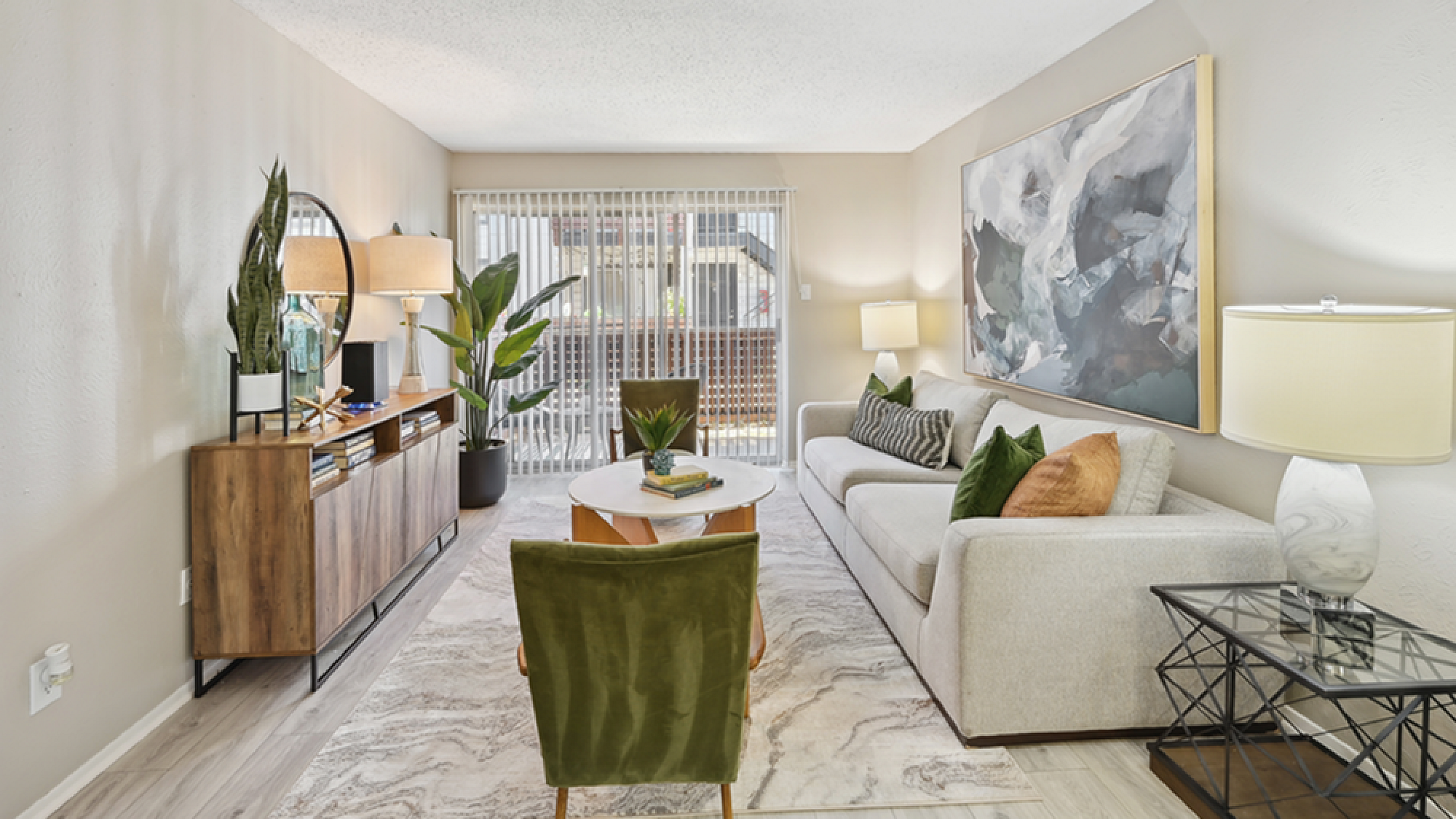 Bright, modern living room with stylish decor, featuring a large abstract painting, cozy sofa, and lush indoor plants for a fresh, inviting ambiance.