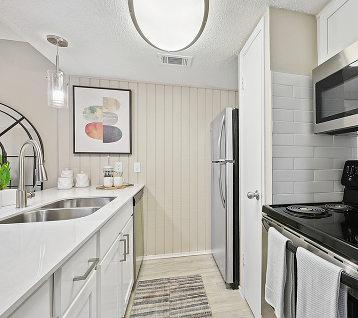 Modern kitchen with sleek stainless steel appliances, elegant white cabinetry, and stylish backsplash.