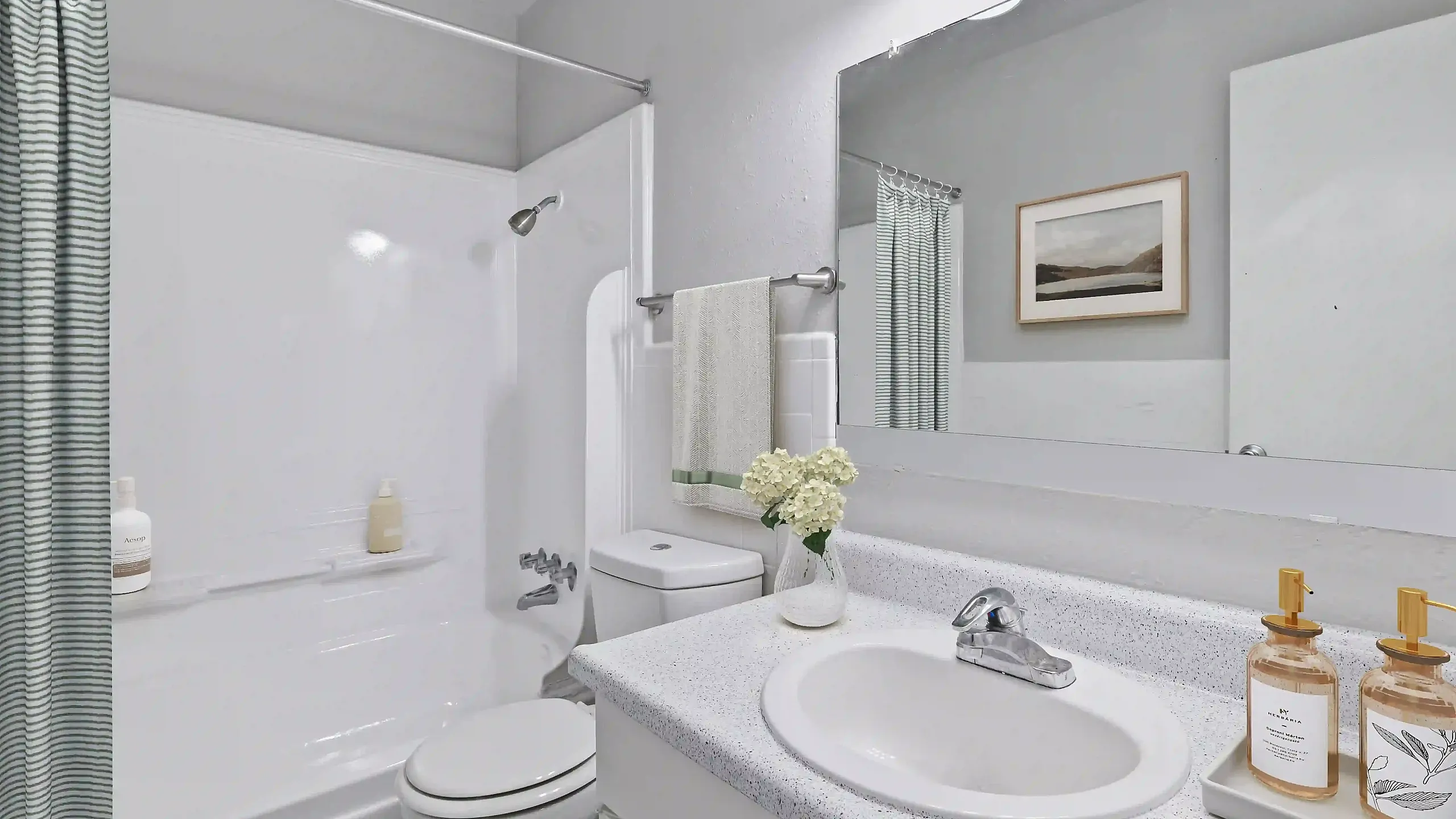 Bright and modern bathroom with sleek fixtures, spacious countertop, and elegant lighting, perfect for relaxation and comfort.